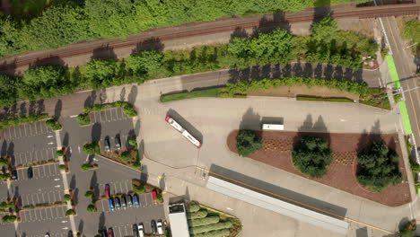 Top-down-aerial-shot-over-bus-pulling-into-Amtrack-train-station