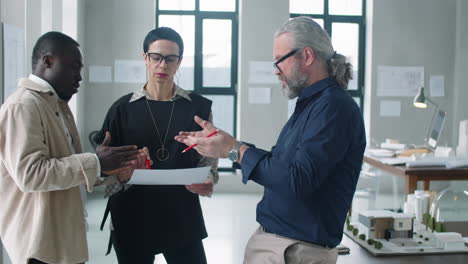equipo multiétnico de arquitectos discutiendo el proyecto de negocio