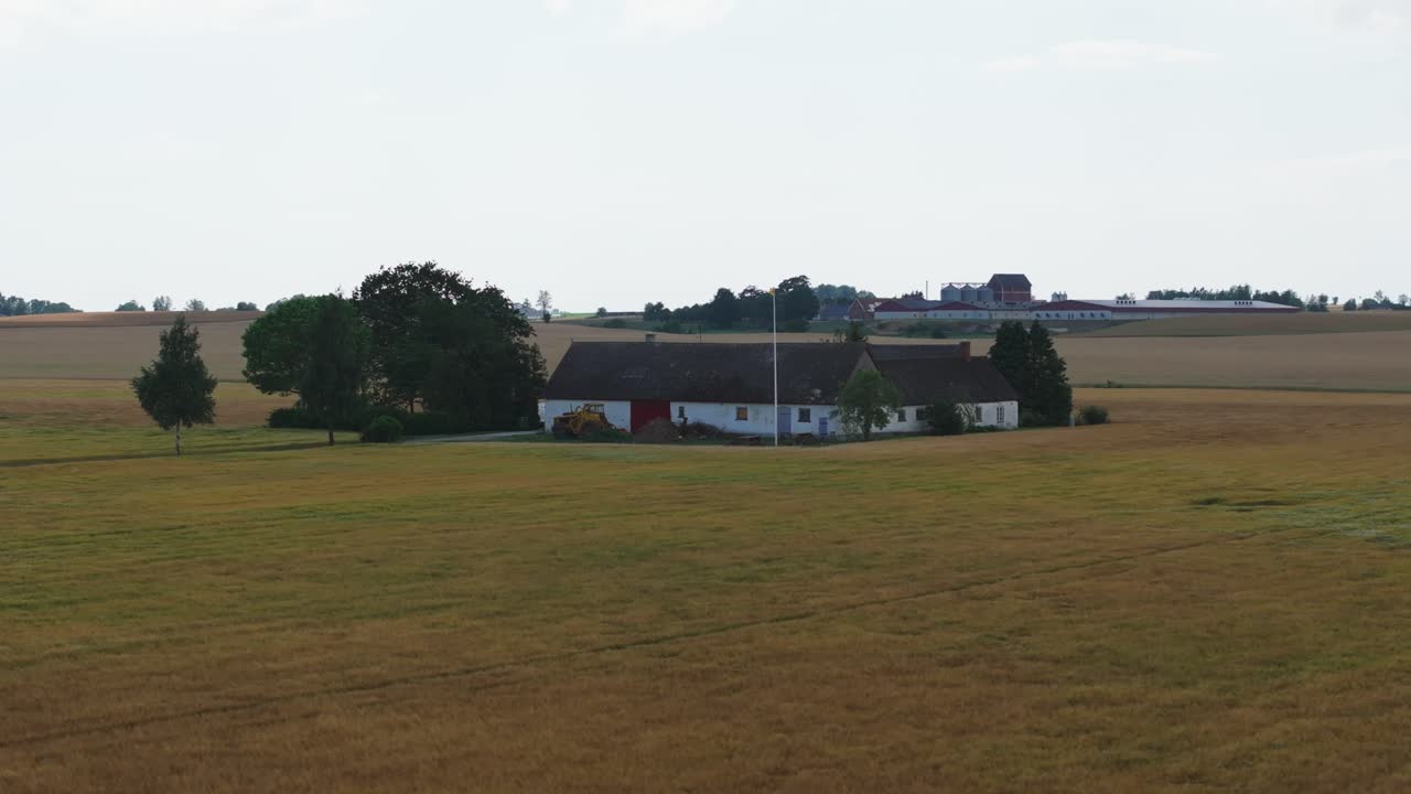edificio agrícola rodeado de campos y pastizales en el campo