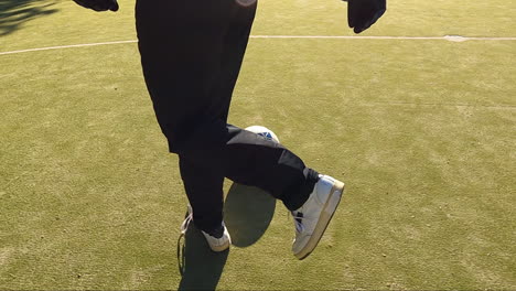 경기장에서 축구공을 가지고 달리는 알아볼 수 없는 골키퍼의 추적 샷