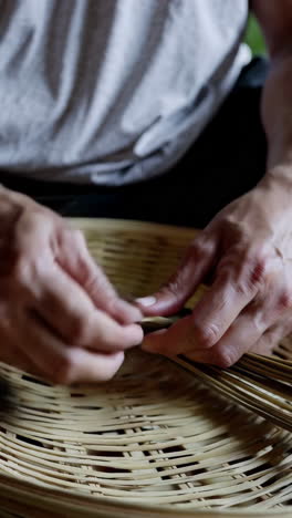 close up of someone weaving a bamboo basket
