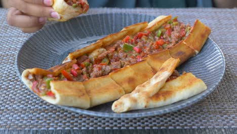 person eating a turkish pide