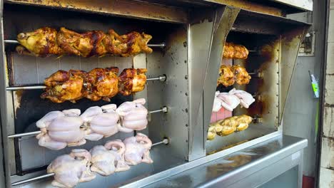 chickens roasting on a rotisserie in thailand