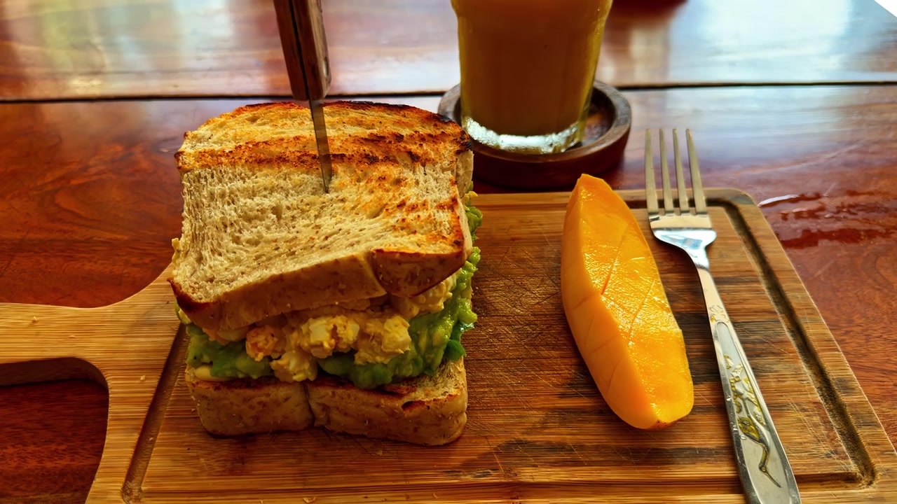 Toast con fetta di mango e caffè su tavolo di legno, primo piano