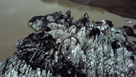 vista aérea sobre el glaciar sólheimajökull, derritiéndose en el agua, durante el verano, en islandia
