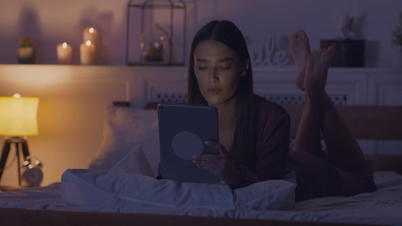 태블릿과 함께 침대에서 휴식을 취하는 여자
