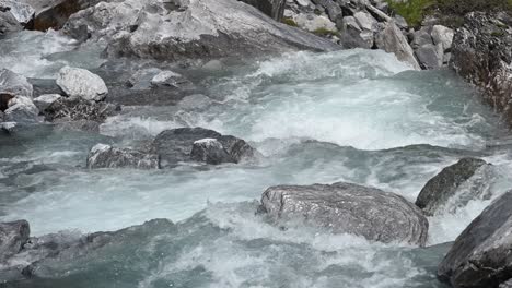 White-foam,-clear-water-and-big-rocks-from-a-mountain-river-in-the-swiss-alps,-Wallis,-Switzerland