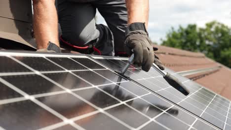 Professioneller-Techniker,-Der-Bei-Tageslicht-In-Zeitlupe-Ein-Solarpanel-Auf-Ein-Dach-Schraubt