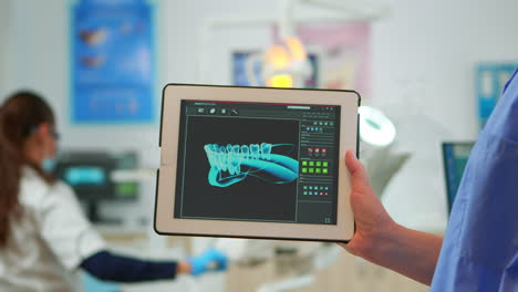 close up dentist assistant holding tablet with digital dental fingerprint