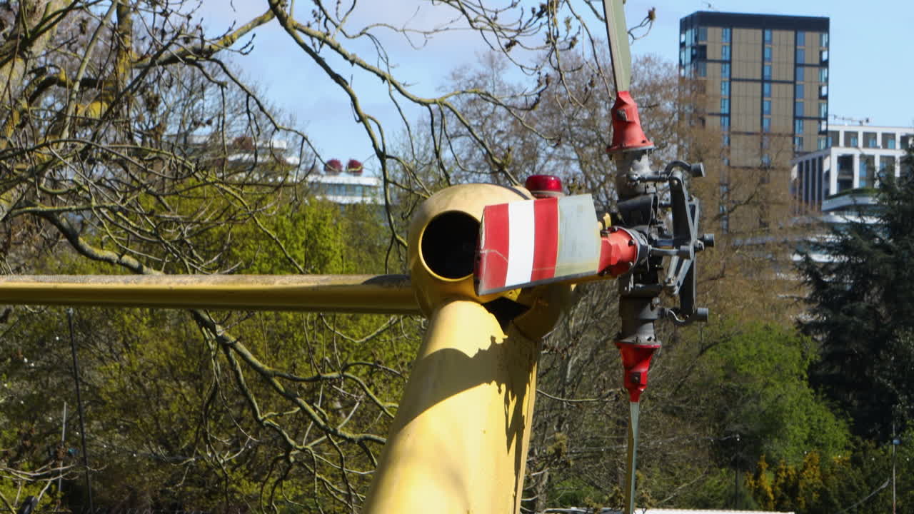 Rotor Blades And Fuselage Of The Back Of A Parked Yellow Helicopter, Close Up Tilting Shot.