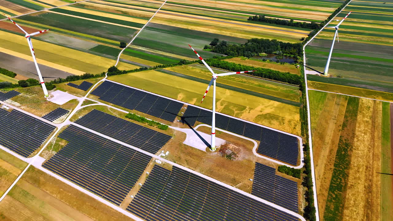 Renewable energy farms in green fields. Wind turbines and solar panels are showcased in a vibrant agricultural landscape during bright daylight