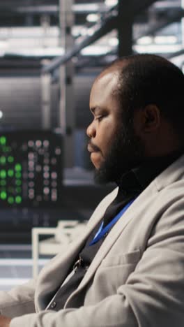 vertical video exhausted server farm employee stretching back