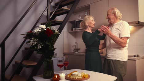 una pareja de ancianos románticos bailando en la cocina