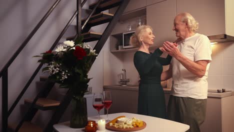 romantic elderly couple dancing in kitchen