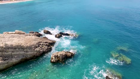 Petani-beach-with-waves-crashing-on-rocky-shores,-kefalonia,-greece,-during-daylight,-aerial-view