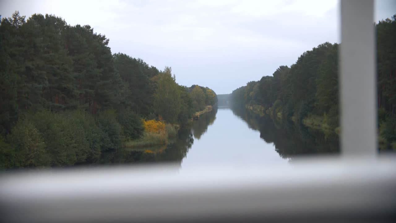 Séquence 4K au ralenti d'un canal maritime en Allemagne avec des arbres verts se reflétant dans la rivière