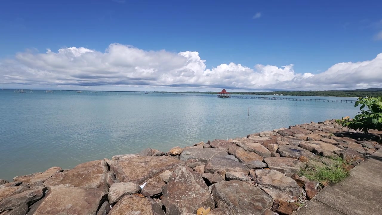 Kivinen rantaviiva Tanjung Lesungin rannalla Indonesiassa, rannikon panorointikuva.