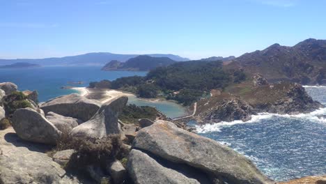 Isla-Montañosa-Con-Acantilados-Y-Playas-Y-Camping-En-El-Fondo,-Día-Soleado,-Tiro-Alto-Panorámico-Girando-A-La-Derecha,-Islas-Cíes,-Pontevedra,-Galicia,-España