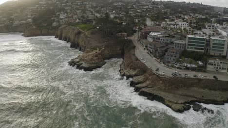 acantilados costeros con olas oceánicas en san diego, california al atardecer - antena