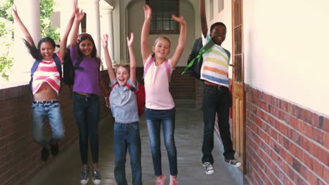 Glückliche-Schüler-Springen-In-Einem-Flur-In-Die-Luft