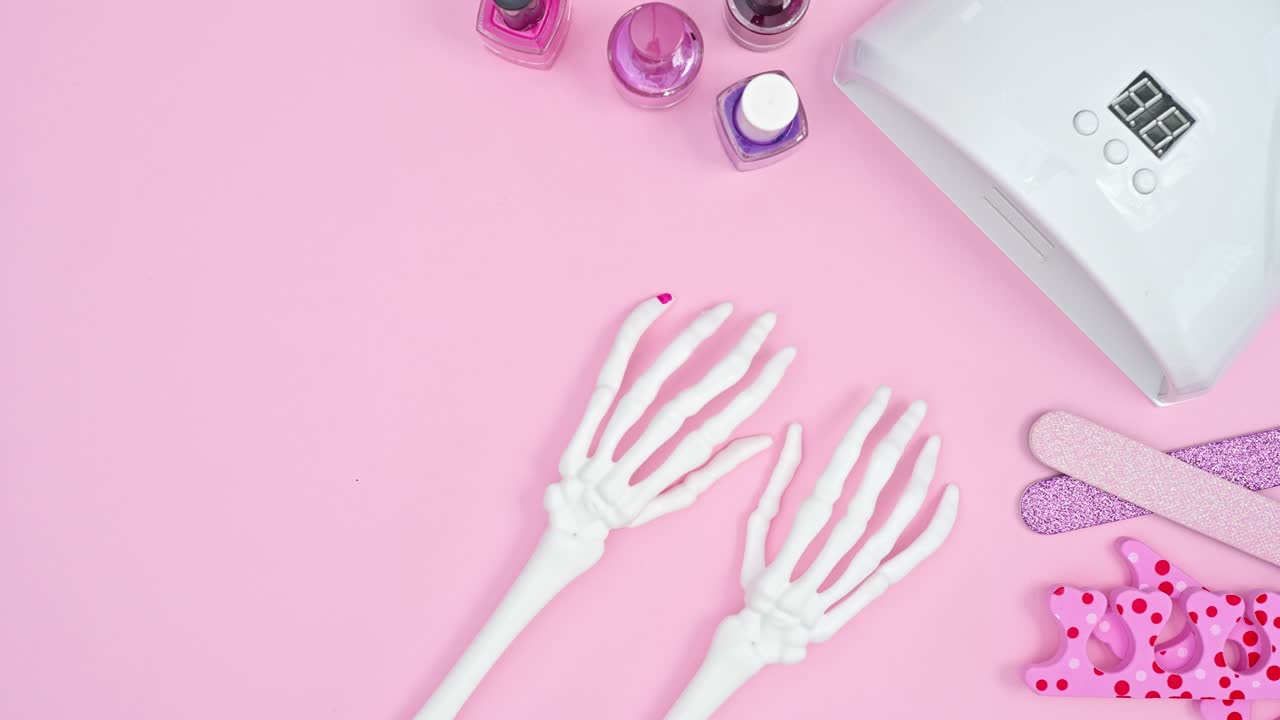 manicure creativo en brazos esqueléticos y con lámpara uv. detenga el movimiento