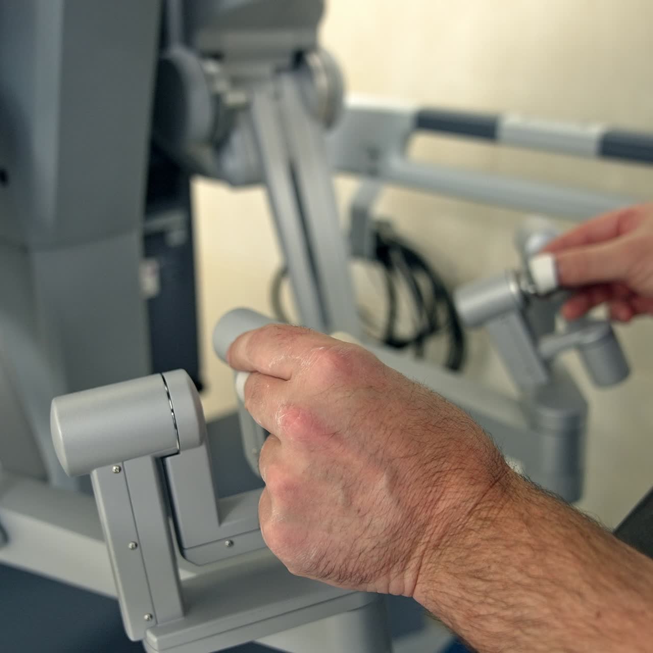 Manual control of the advanced robotic equipment in surgery room. Male hands operating Da Vinci robot close up