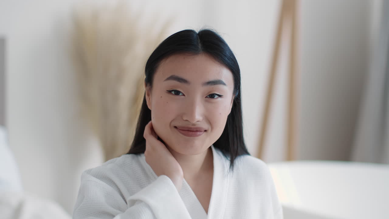 Asian woman in white robe smiling
