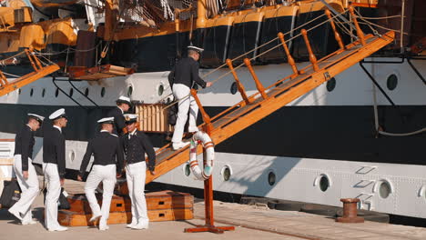 sailors boarding a historic ship