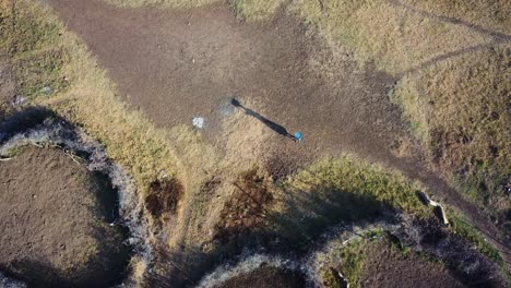 fotografía aérea de una mujer karamojong cargando cosas con la cabeza, uganda