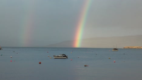 토버모리 (tobermory) 에 정박한 배 위에 있는 활기찬 이중 무지개 (double rainbow) 의 손으로 찍은 사진