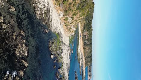 Vuelo-Vertical-De-Drones-Sobre-La-Hermosa-Costa-De-Piedra-Escarpada-En-Un-Día-Despejado