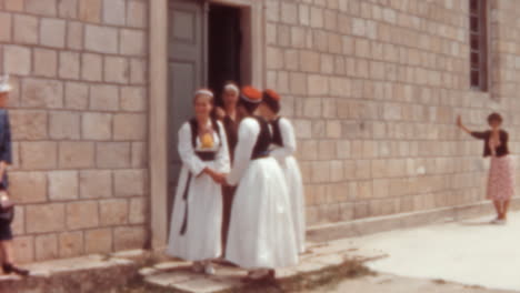 women in traditional croatian costumes leaving historic stone building 1960s