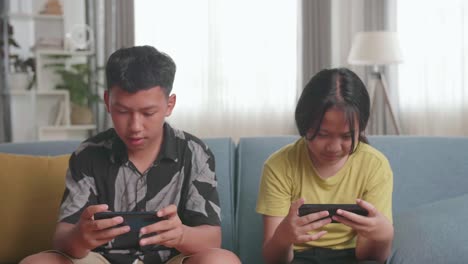 siblings playing games on mobile phones