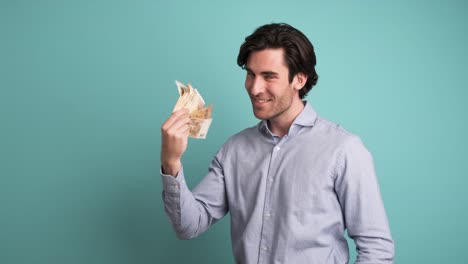 cheerful rich man counting euro banknotes in blue studio