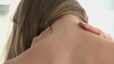 close up of a woman holding her neck