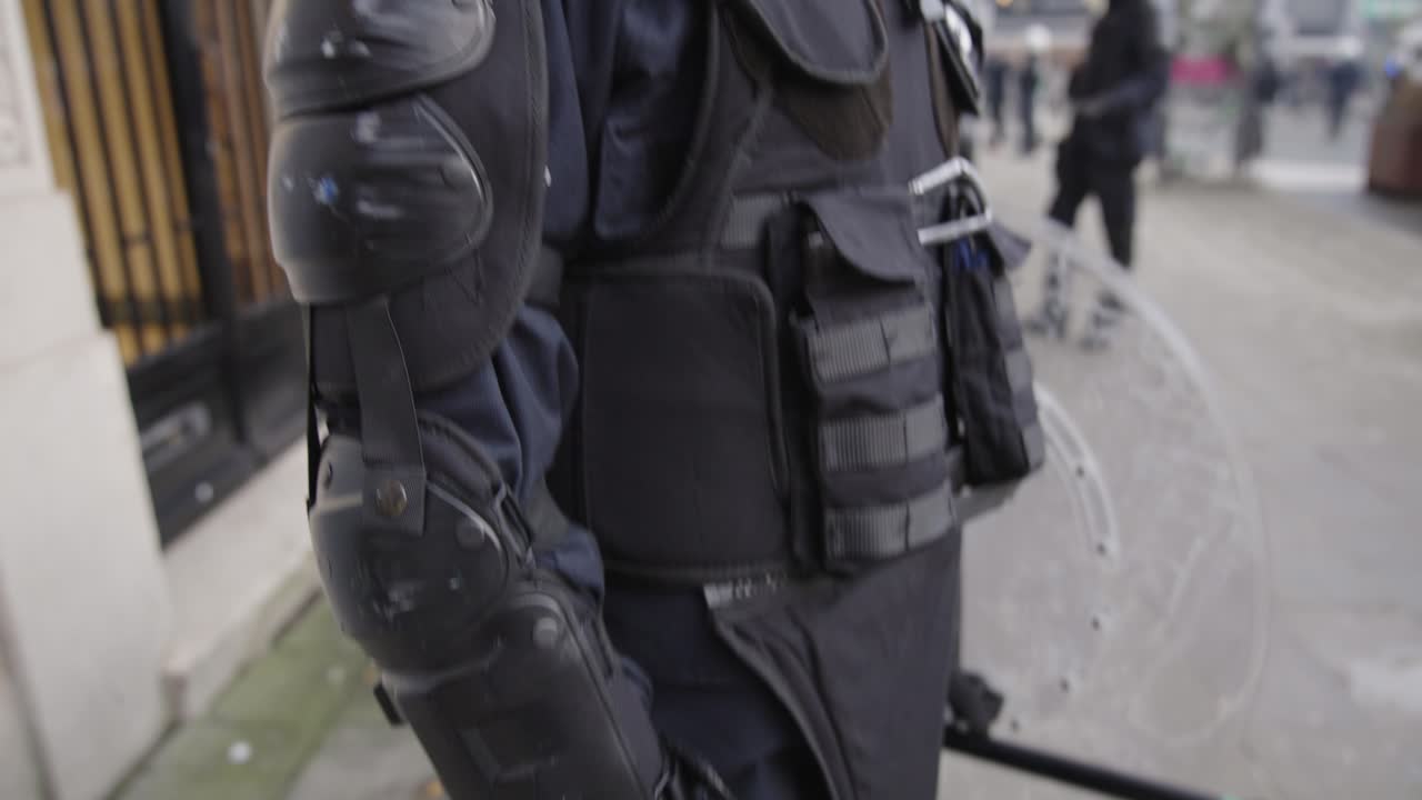 A Belgian police officer with gas mask dressed in full riot gear preparing for protests