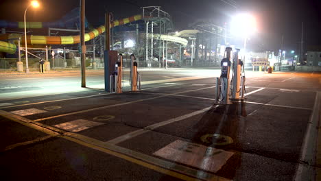 Estación-De-Carga-De-Coches-Eléctricos-Por-La-Noche-En-Un-Aparcamiento-Vacío