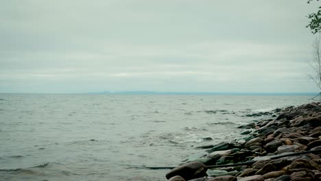 lake superior waves rolling into shore with distant mountains at the horizon