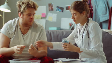 female doctor discussing pills with patient during home consultation