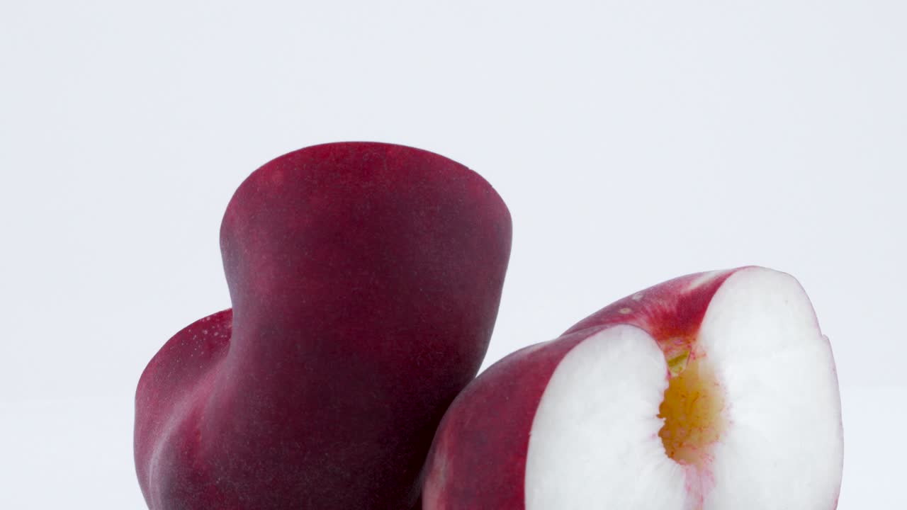 macro disparo de dos mitades de un donut de melocotón plano con el hoyo. girando lentamente en la mesa giratoria aislada en el fondo blanco. primer plano