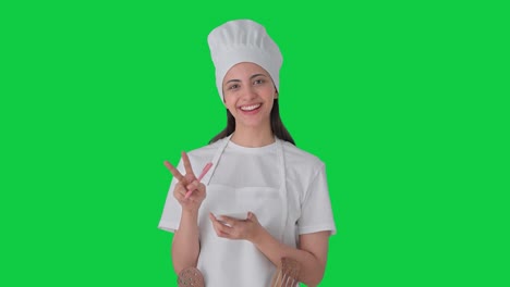 mujer india feliz chef profesional anotando la receta pantalla verde