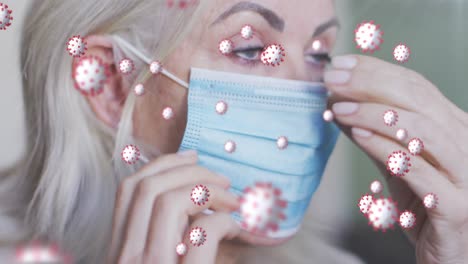 animation of virus cells over senior caucasian woman with face mask