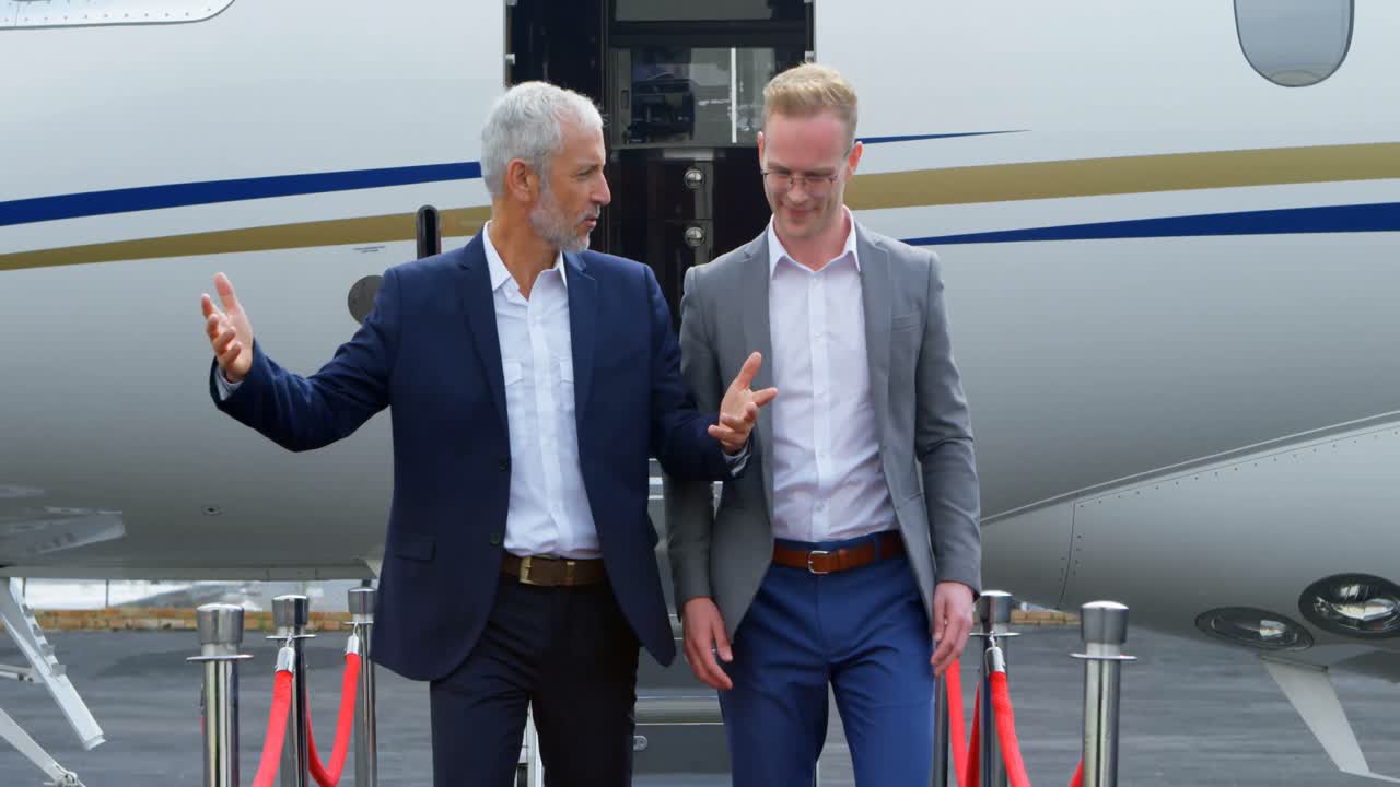 Persone d'affari tra loro mentre scendono da un jet privato 4k