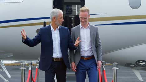 business people interacting with each other while moving out from private jet 4k