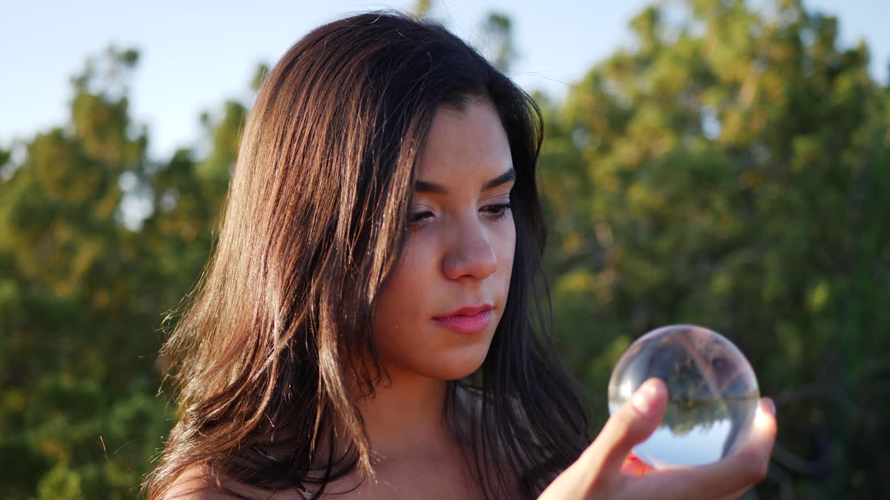 A beautiful woman in a mystical fantasy land casting a spell or enchantment with her magic crystal ball CLOSE UP