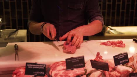butcher expertly cuts meat at a market