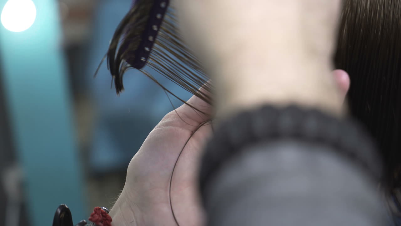 Hairdresser cutting hair of her customer at the hairdressing salon