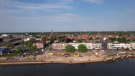 Baustelle-Der-Mittelalterlichen-Stadt-Von-Oben-Gesehen-Mit-Binnenschifffahrt-Großes-Frachtschiff-Verlässt-Kräuselwellen-Auf-Dem-Fluss-Ijssel-Vorbei-Am-Ijsselkade-Boulevard-Stadtbild-Der-Turmstadt-Zutphen