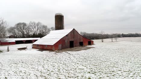 Low-Flying-Drone-Shot-of-Red-Hay-Barn-in-the-Snow-Tennessee