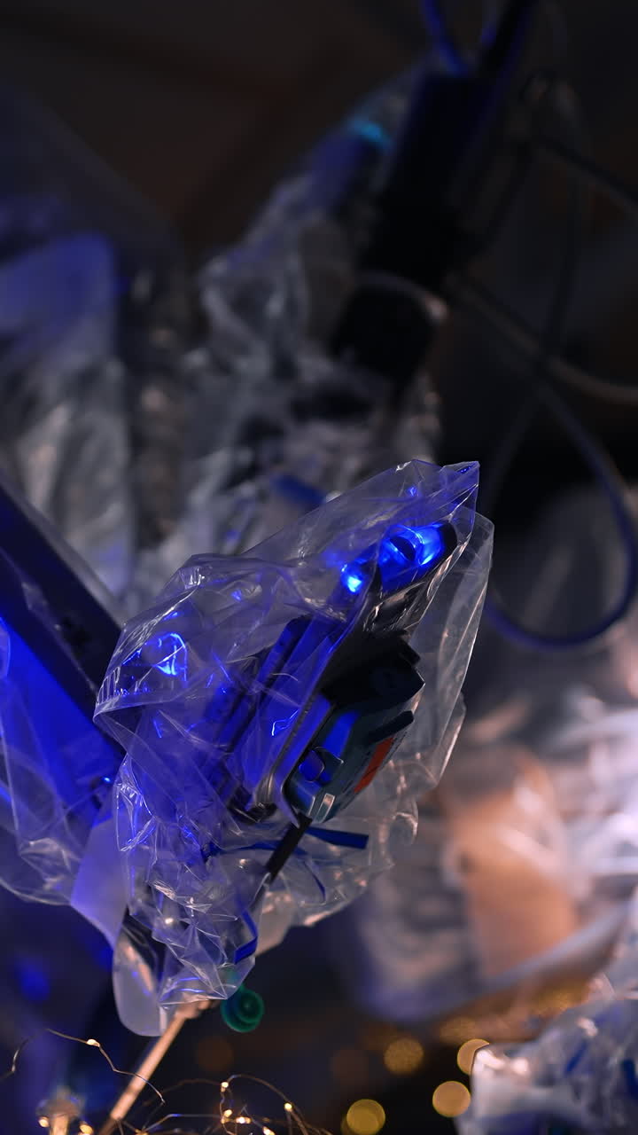 Futuristic robotic arms covered with plastic moving in the dark surgery room. Christmas decorations on the operational table. Vertical video